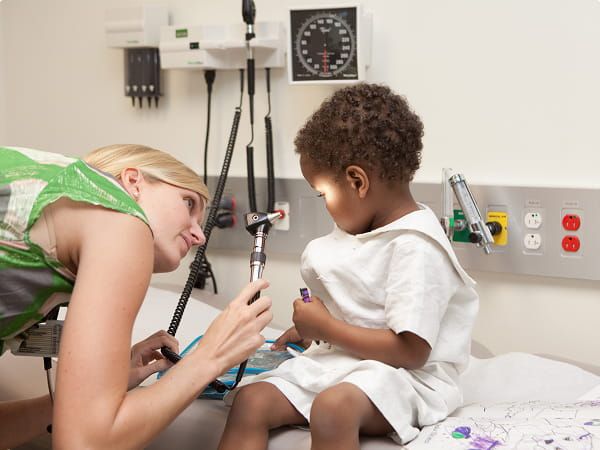 Doctor examining a young child during a medical checkup.