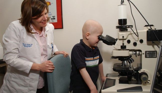 young boy named Mason with female doctor looking into microscope