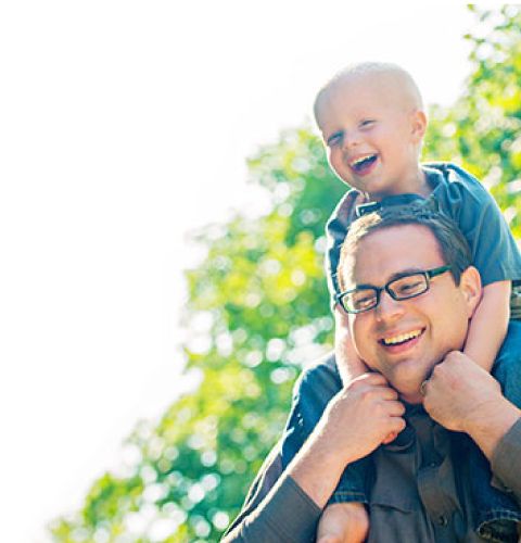 Father with son on his shoulders laughing