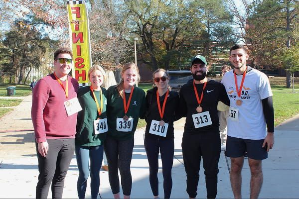 A group of six participants standing together near a finish line.
