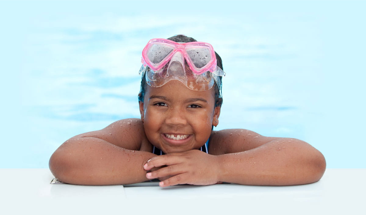 Picture of a young girl smiling in a swimming pool