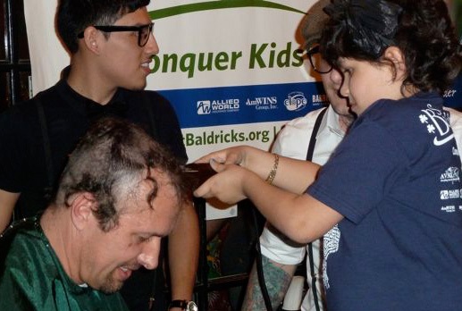 Dr. Dean Lee getting his head shaved to help fund childhood cancer research