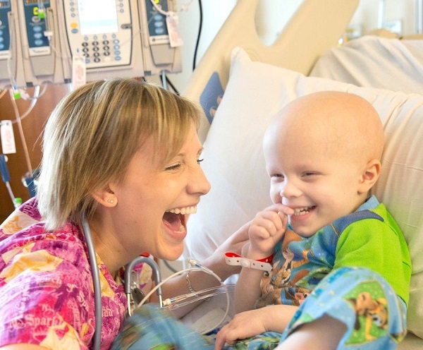 Chase laughs with one of his pediatric oncology nurses
