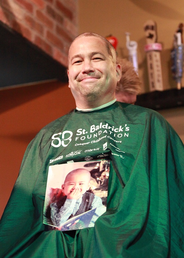 Alan's father shaving his head to raise money for pediatric cancer research