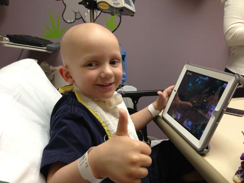 Israel smiles and gives a thumbs up on his last day of chemo