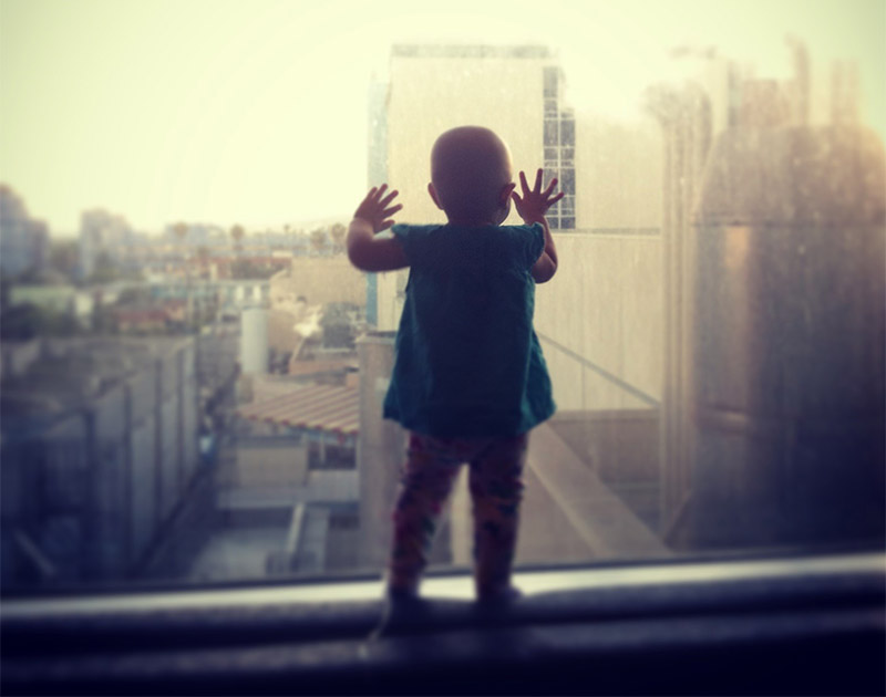 Lilly gazing out the hospital window while she was in treatment for childhood cancer