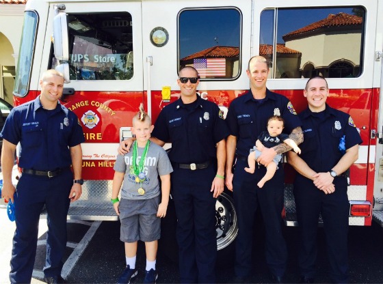 Honored Kid Ayden stands with Chris' crew in front of their engine.