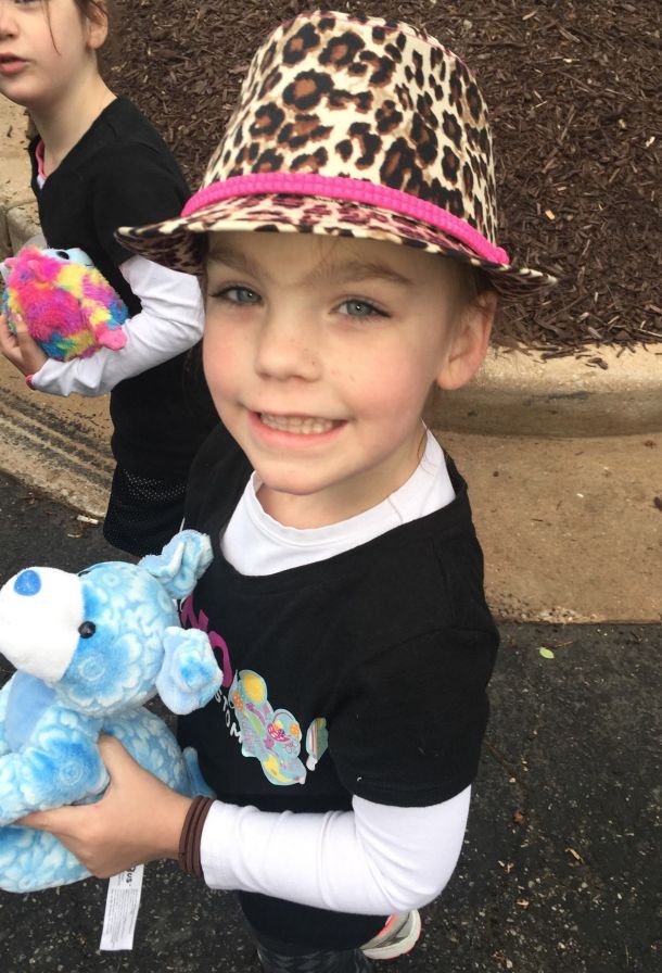 Roxie smiles at the camera while wearing a leopard-print fedora