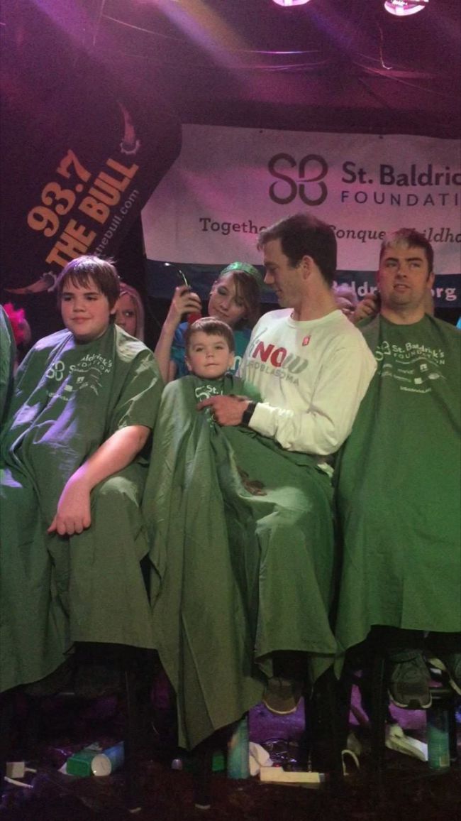 Roxie's little brother sits in a barber's chair and shaves for St. Baldrick's