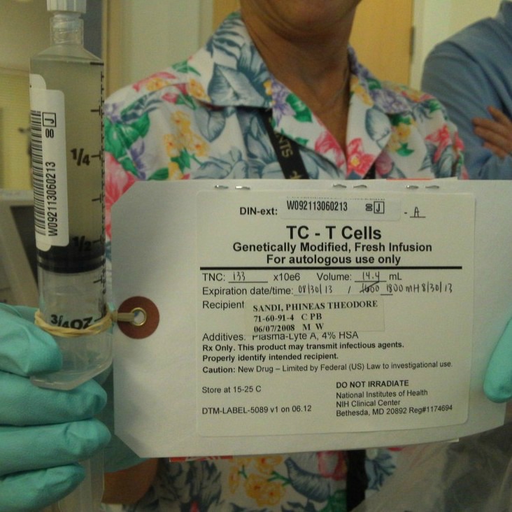 A nurse holds the single syringe of modified T cells used during Phineas's immunotherapy