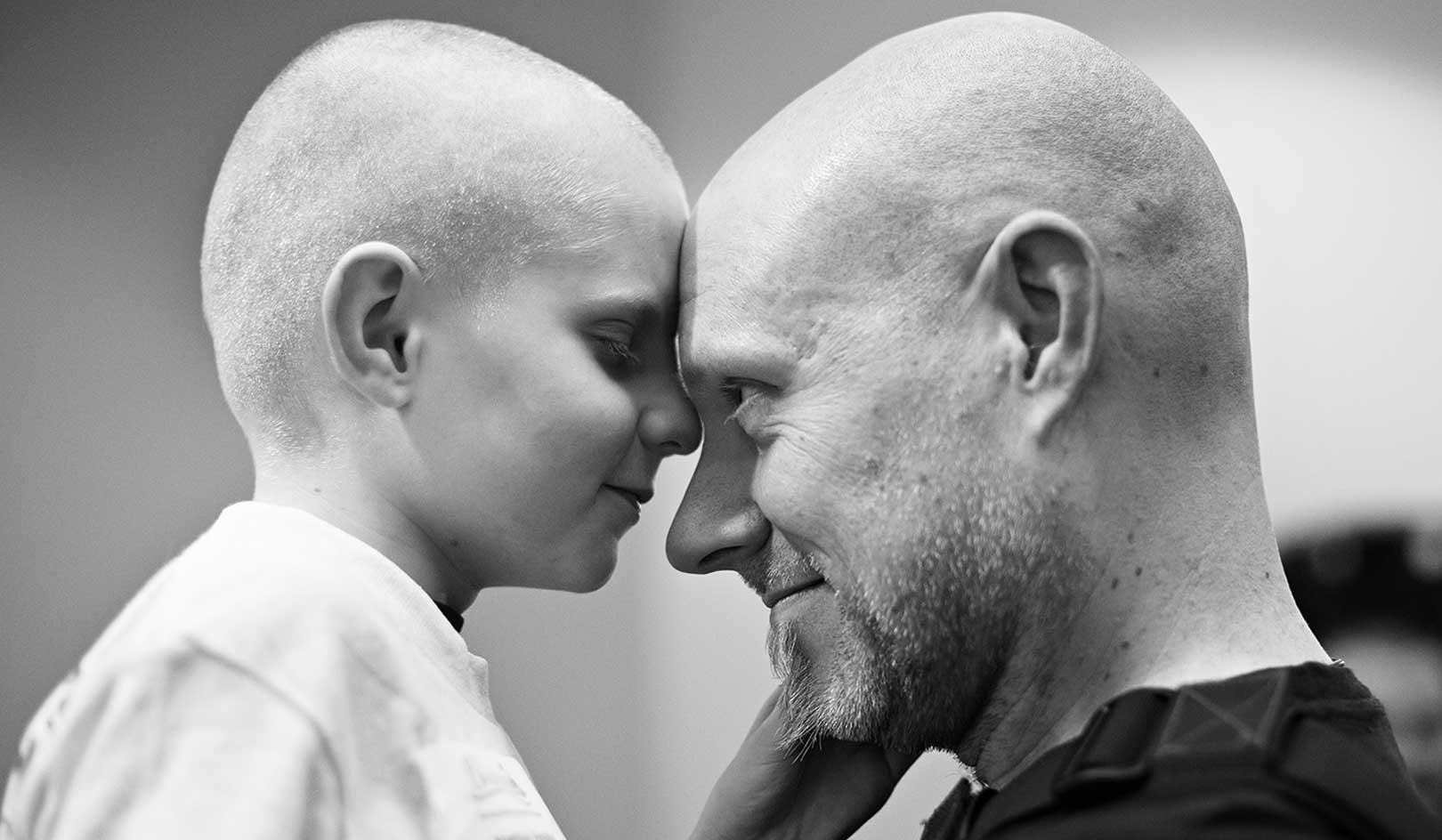 Matthias, who had retinoblastoma, hugs his father after they shaved for St. Baldrick's.