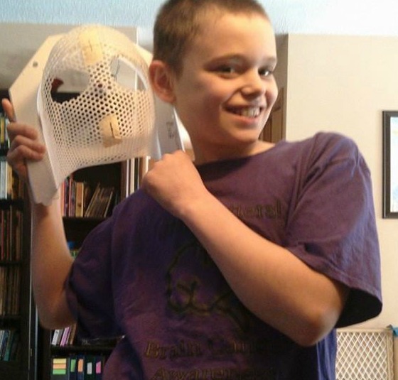Jeremy smiles while holding his radiation mask