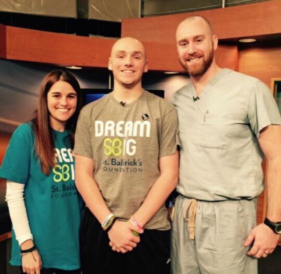 Josh stands with his barber and a fellow shavee after going bald on live TV