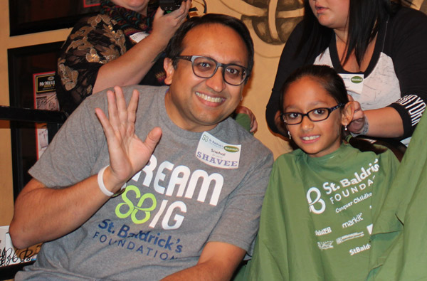 Hridi and Snehal Bhakta wave at the camera right before shaving their heads