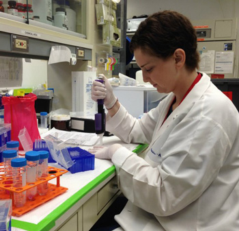 Lauren holding a pipette while working on a neuroblastoma immunotherapy research project