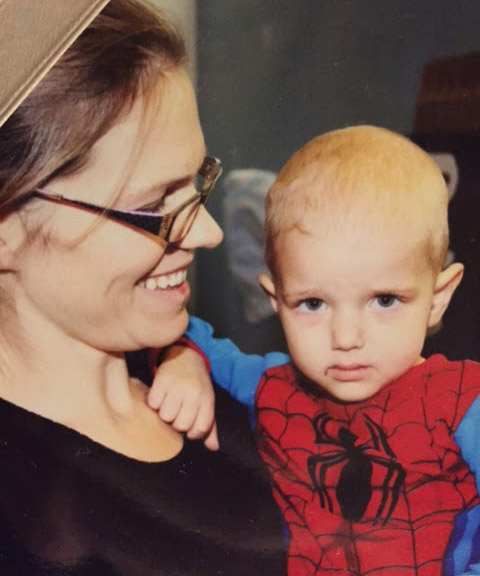 Cindy holds a bald Ty in a Spiderman costume