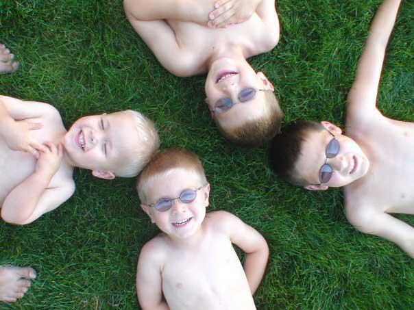 The four boys enjoying the grass.