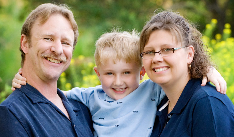 Sam between his father, Jay, and his mother, Tammy.