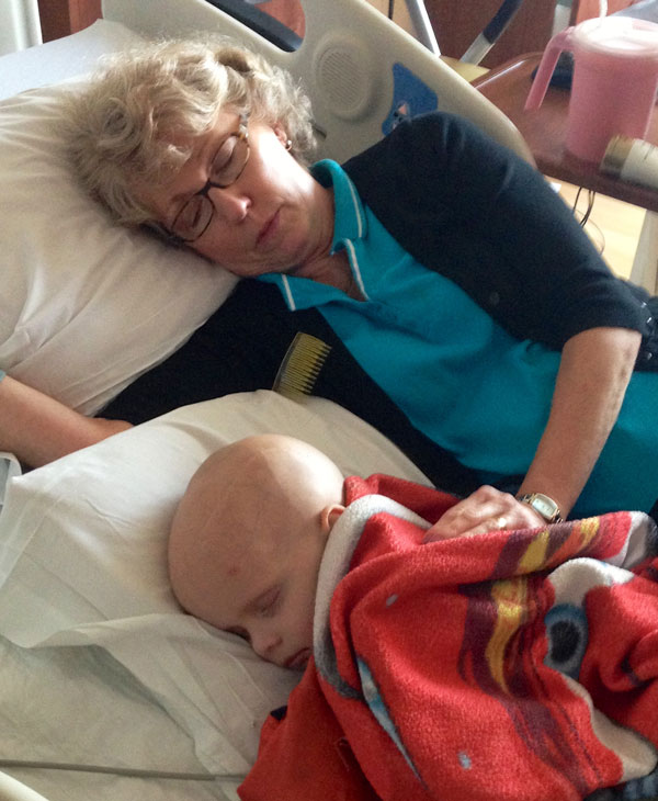 Chase and his grandma sleeping in the hospital bed while Chase was in treatment for ATRT