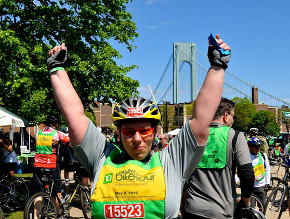 Susan throwing her fists in the air at the end of her first Five Boro Bike Tour