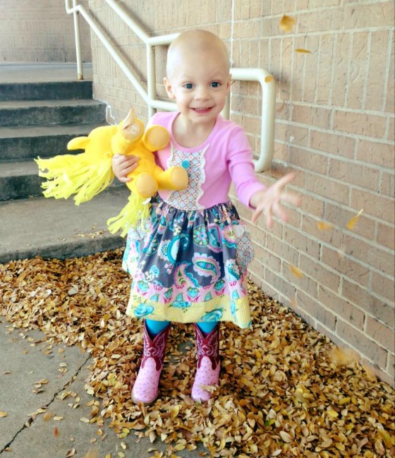 Avery smiles as she throws fall leaves in the air