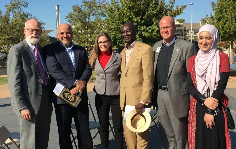 Imam Enchassi and Rabbi Harris stand together with other faith leaders at an interfaith meeting