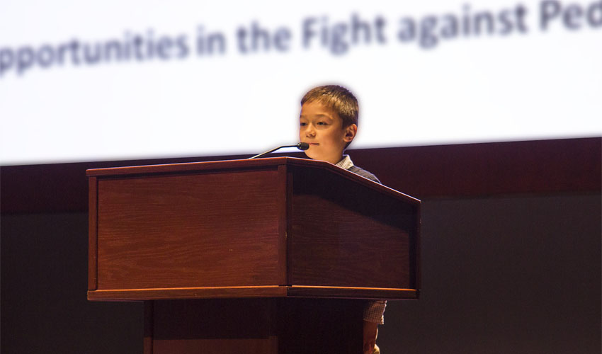 Scott speaking at the podium on Capitol Hill during the Childhood Cancer Summit