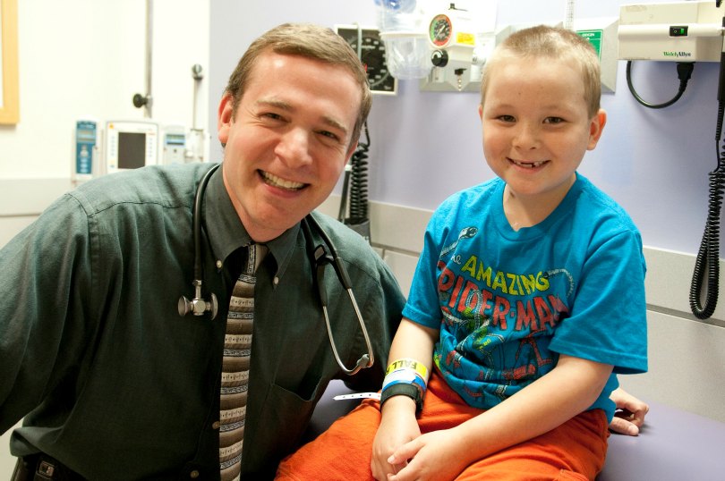 Dr. Friedman smiles with a young patient in an exam room