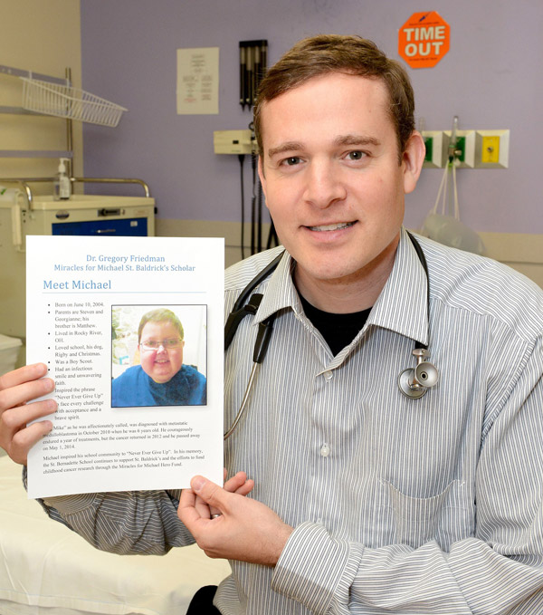 Dr. Friedman holding a photo of Michael Orbany