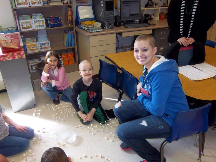 Taylor sits with Josh and his classmates as they work on a project.