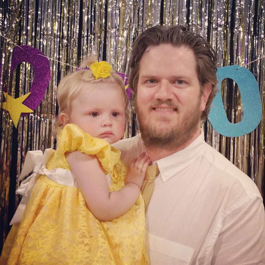 father and daughter pose at a party