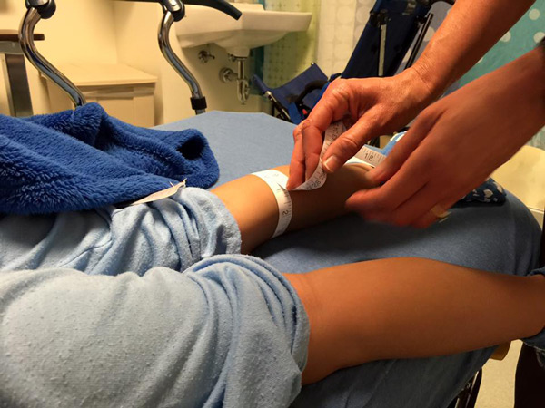 A nurse holds a tape measure around Daisy's calf