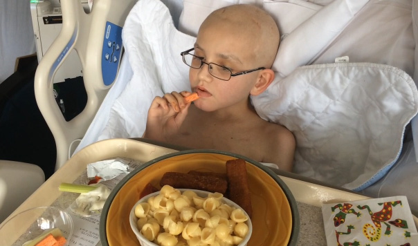 Luke eyes a tray of hospital food