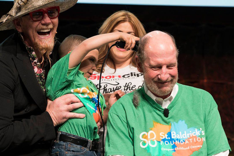 Honored Kid Derryk shaves the Sport Clips CEO's head