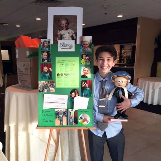 Nathan stands next to his St. Baldrick's poster board at his bar mitzvah