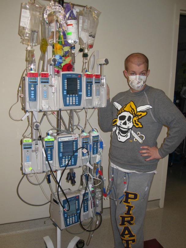 Sarah poses next to her chemo bags