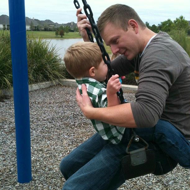 Liam with his dad on a swing