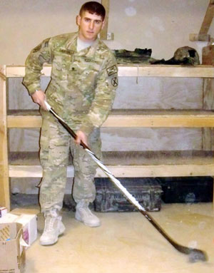 Johnny in his army uniform holding a hockey stick