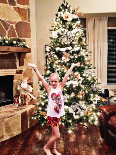 Sadie twirls next to the Christmas tree