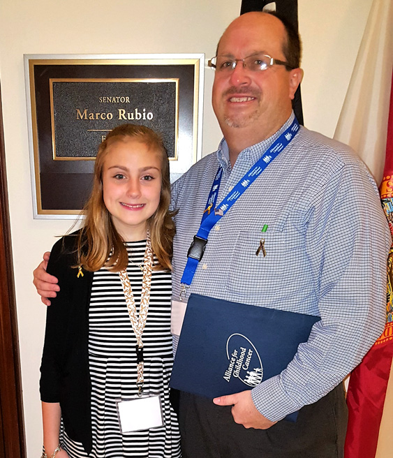 kids' cancer survivor standing with her dad outside Sen. Marco Rubio's office