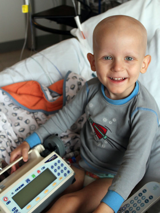 Caemon sitting in his hospital bed