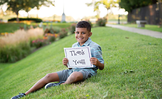 Isaac holding sign saying thank you