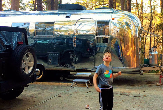 Phineas standing in front of vintage Airstream