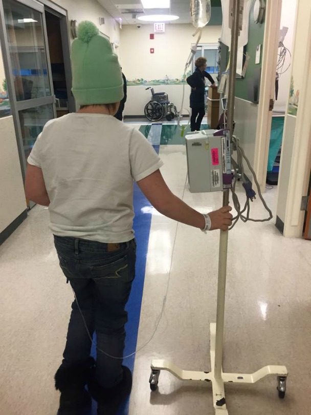 Zayla walks down the hall at the hospital during treatment