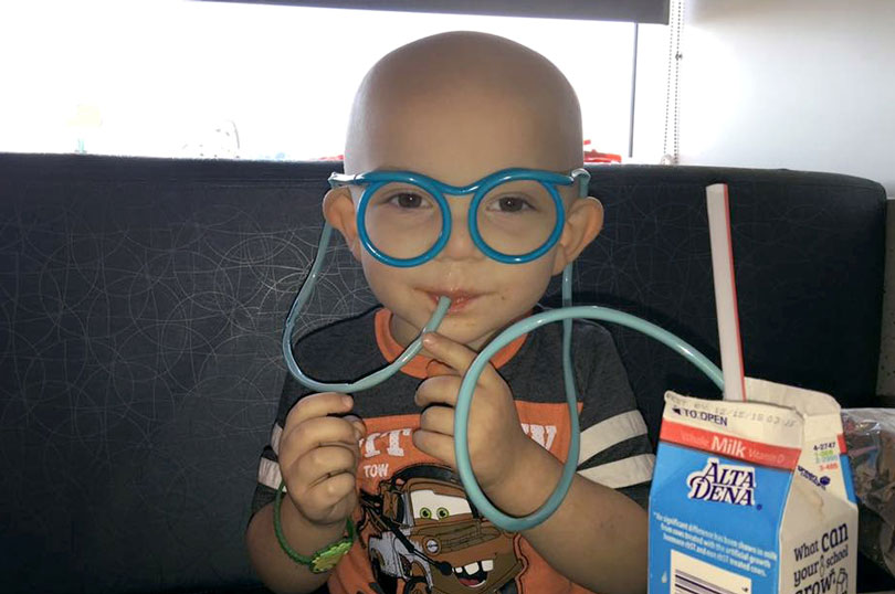 Aiden drinking milk out of straw glasses