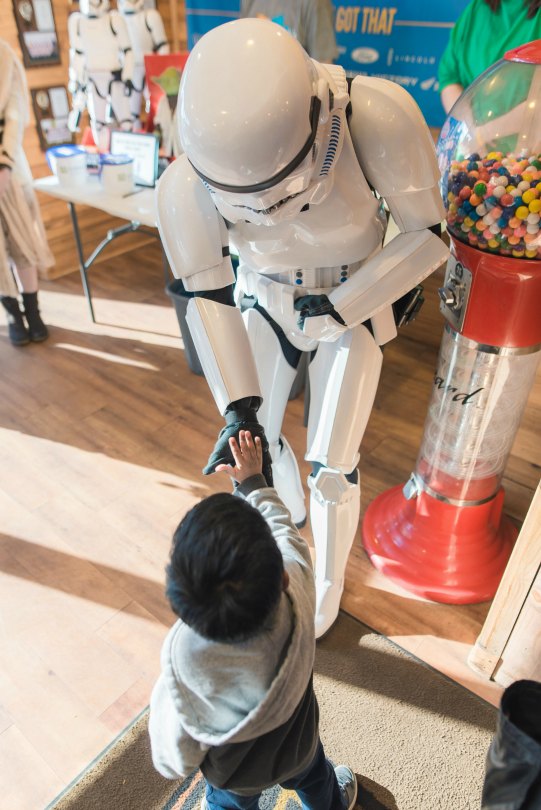 A stormtrooper gives a kid a low-five