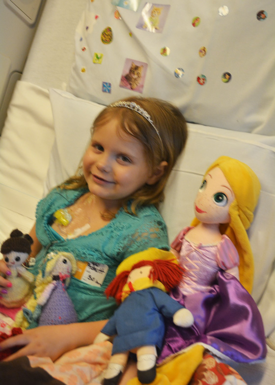 Hazel in her hospital bed surrounded by toys