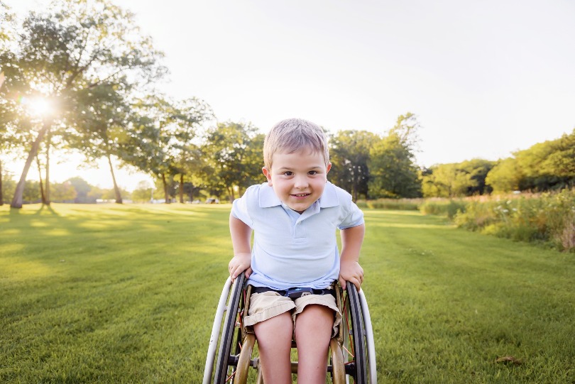 Kellan grins from his wheelchair