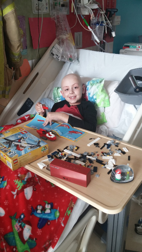 Ori plays with Legos in his hospital bed