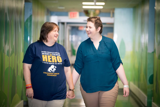 Emily and her mom hold hands as they walk around the hospital